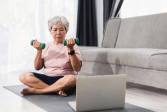 Older woman exercises at home to prevent falls.