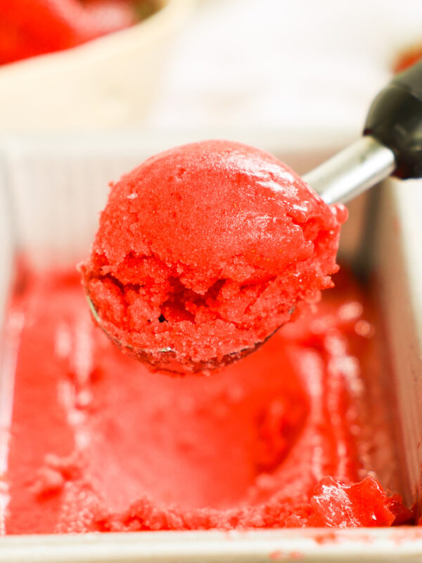 An up-close shot of a scoop of strawberry sorbet.