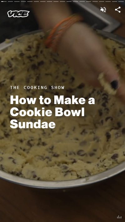 A closeup of a person's hand assembling a Cookie Bowl Sundae.