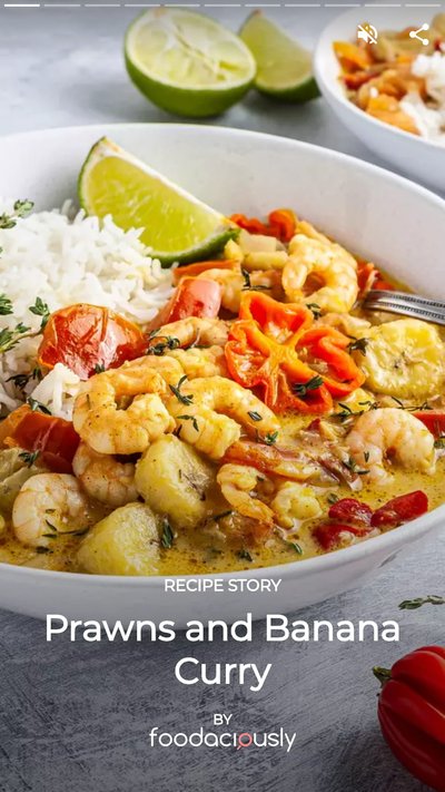Prawns and banana curry in a bowl garnished with limes