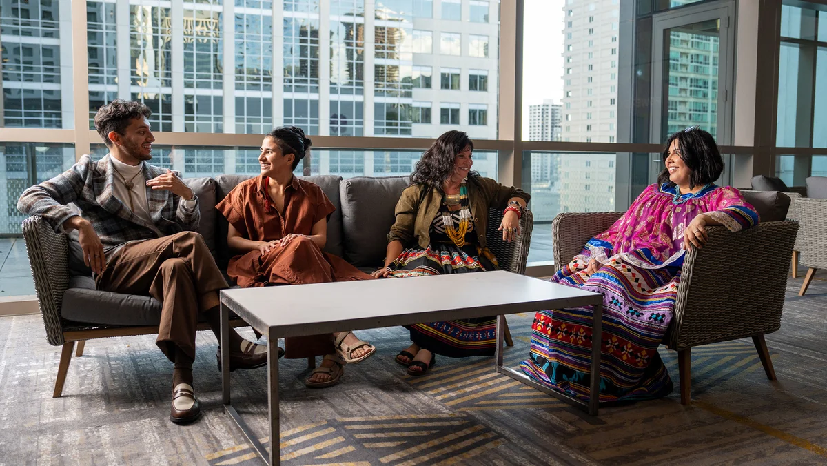 Four people sitting around a table talking at a Natives in Philanthropy event.