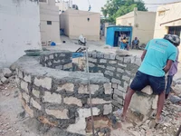 A person fixes a water well.
