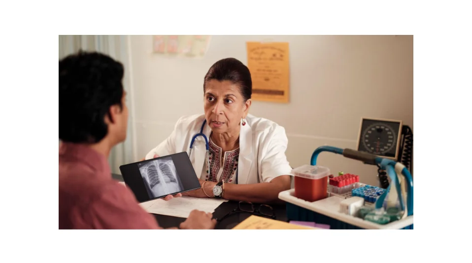 A doctor and patient are discussing an image on a tablet
