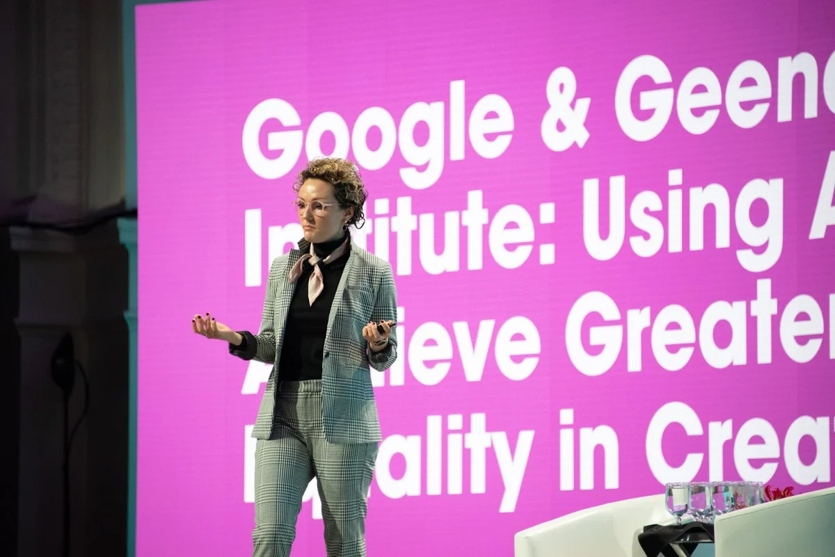 Mackenzie Thomas standing on stage speaking at a Google conference with the Geena Davis Institute.