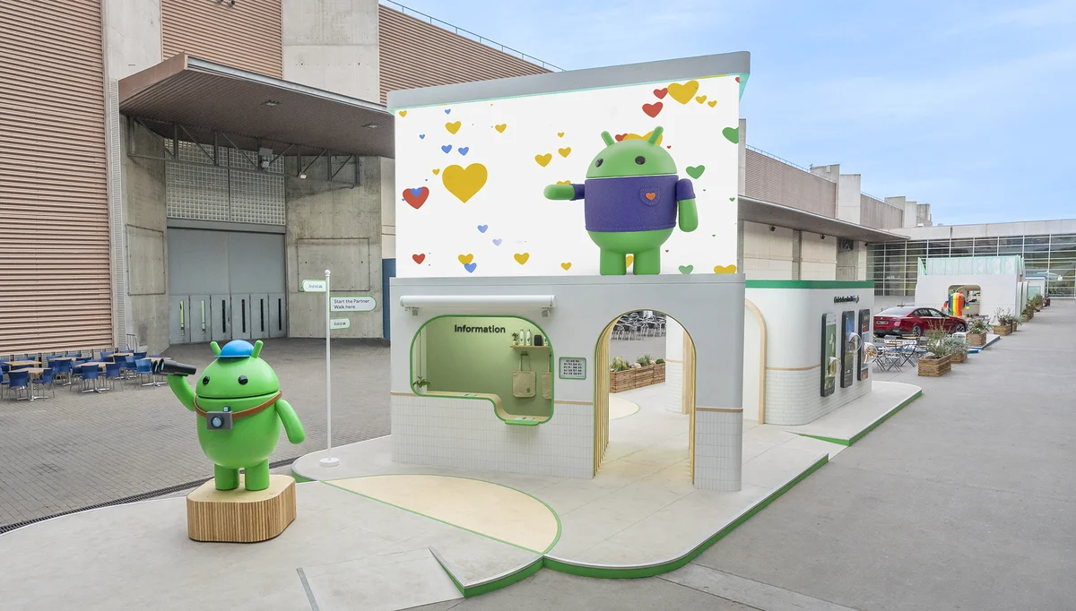 Image of Android open space at MWC event - green android robot statue in front of billboard.