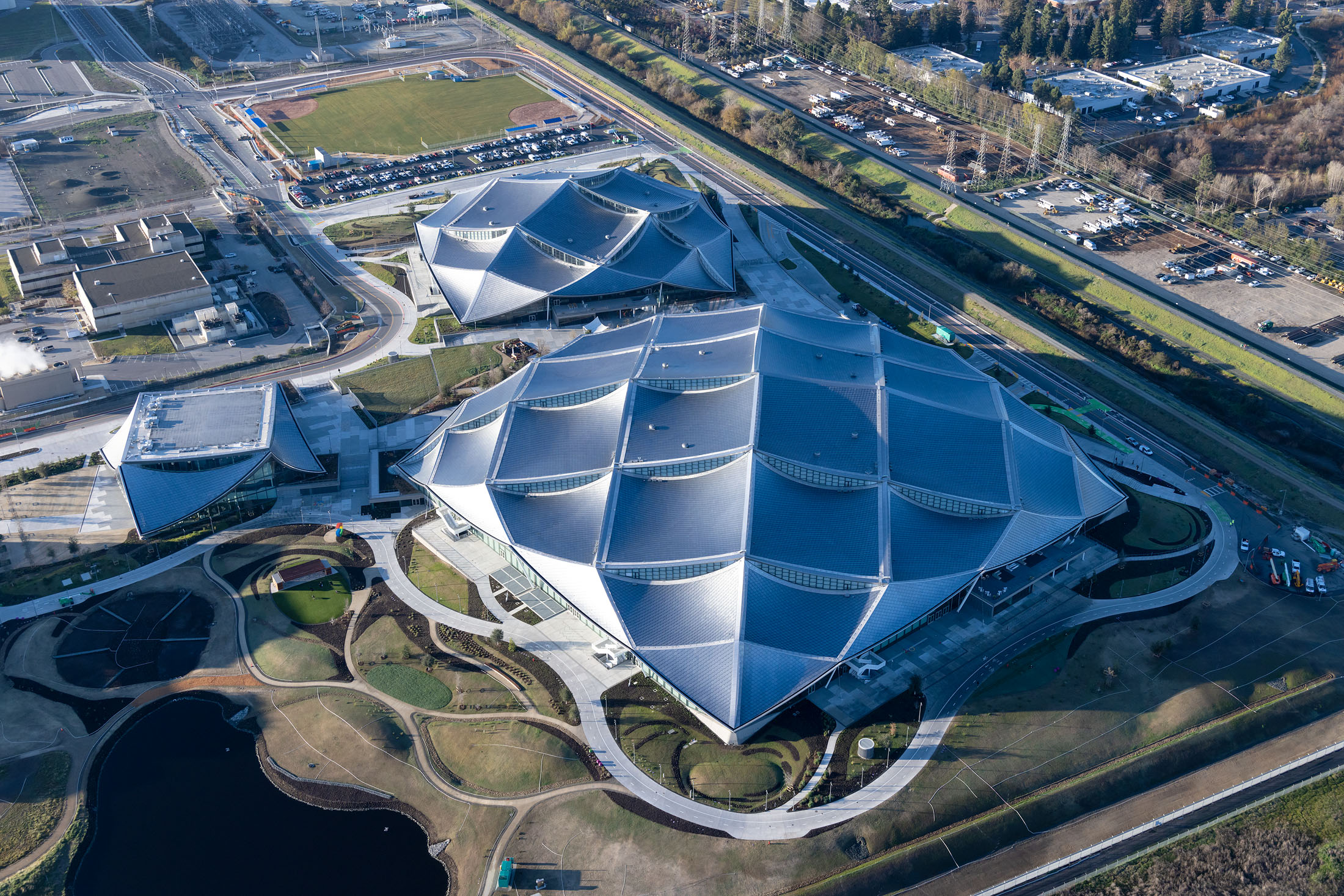 An aerial photo of three large canopies that are covered in solar panels.