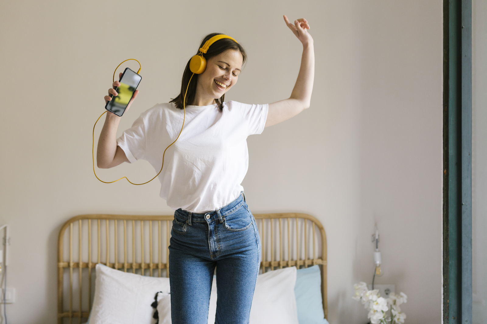 Woman with headphones on dancing happily to music