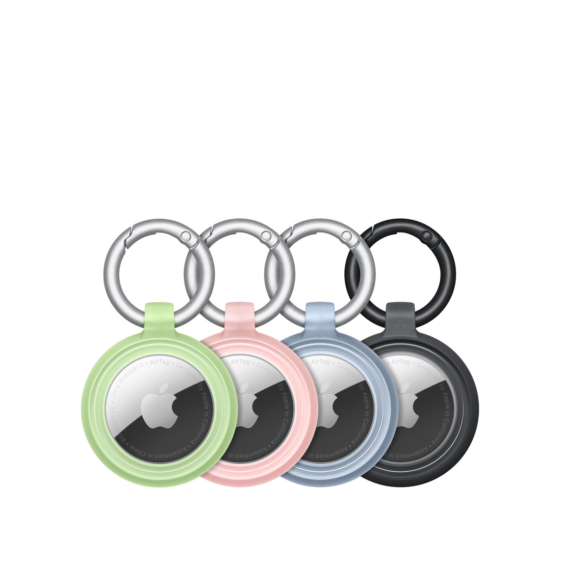 Fyra AirTag-enheter som sitter säkert på plats i OtterBox Lumen Series-skal i grönt, rosa, blått och svart, med Apple-logotypen synlig i mitten.