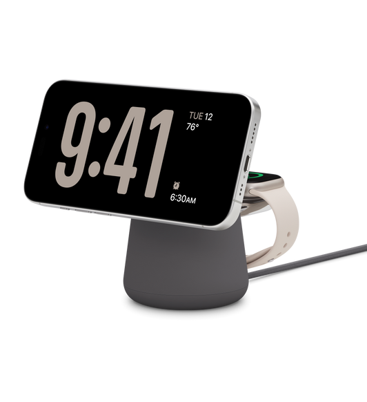 Na černém bezdrátovém nabíjecím doku Belkin Boost Charge Pro 2-in-1 s MagSafe se nabíjí současně bílý titanový iPhone 15 Pro a Apple Watch Series 9 se 41mm hvězdně bílým pouzdrem.
