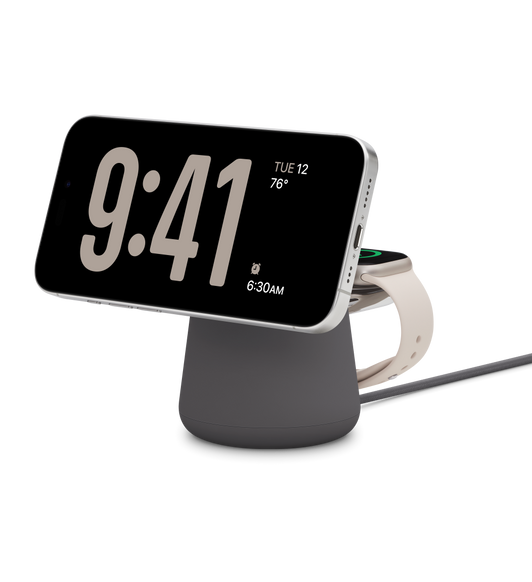 图片展示支持 MagSafe 的黑色 Belkin Boost Charge Pro 二合一无线充电基座，同时为白色钛金属外观的 iPhone 15 Pro 和 41 毫米星光色表壳的 Apple Watch Series 9 充电。