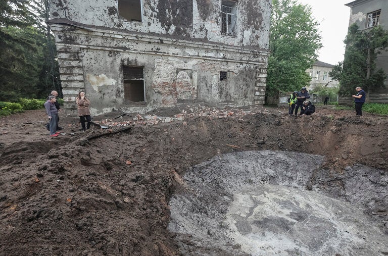 Residents and police officers inspecting a crater at the site of a Russian missile strike in Kharkiv, Ukraine, on Saturday.