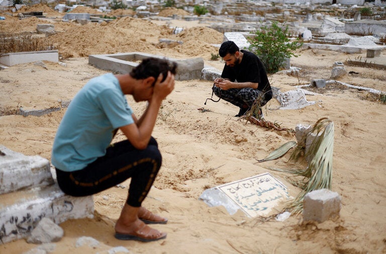 An uncle of a girl who was born after a strike in southern Gaza mourned by her grave in Rafah on Friday.