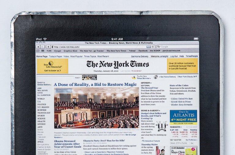 What resembles an iPad screen is a printed screenshot of The New York Times’s digital home screen pasted on a piece of paper. 