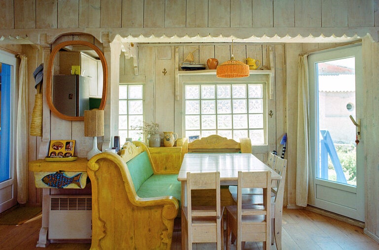 Carousel-inspired banquettes and a dining table in the main room of the cabanon, a retrofitted 1960s fisherman’s cottage.