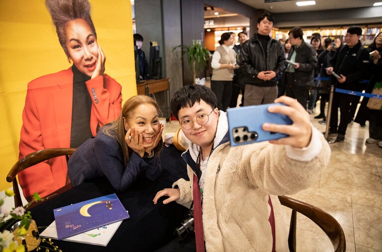 Kim In-soon, known professionally as Insooni, taking a picture with a fan at a book signing in Seoul in March.